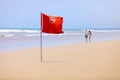 Tropical beach and a red flag. Do not swim! Royalty Free Stock Photo