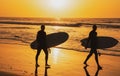 Tropical beach sea ocean with sunset or sunrise for summer travel vacation. Silhouette of surfer people carrying their Royalty Free Stock Photo
