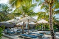 Tropical beach with sunbeds and umbrellas near pool Royalty Free Stock Photo