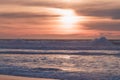 Tropical beach sunset in soft blue and pink colors. Empty sand beach, huge waves, and beautiful cloudy sky Royalty Free Stock Photo