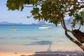 Tropical beach with trees, boats and isles on horizon. Seascape with tourists in boat. Tropic paradise.