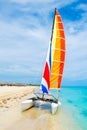 The tropical beach of Varadero in Cuba with a colorful sailboat