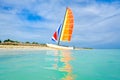 The tropical beach of Varadero in Cuba with a colorful sailboat