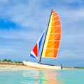 The tropical beach of Varadero in Cuba with a colorful sailboat