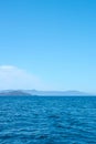 Tropical blue sea and blue sky with mountains on a horizon as a natural background. Royalty Free Stock Photo