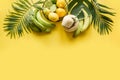 Tropical border of fruits, banana, lime, leaves palms on punchy yellow background. Space for text. Detox tour
