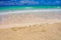 Tropical Caribbean beach in Bahamas with bright blue sky, turquoise water and writing on the sand Royalty Free Stock Photo