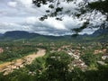 Tropical city in Laos, South East Asia that is divided by a large brown colored river seen from a distance Royalty Free Stock Photo