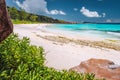 Tropical coast at La Digue island, Seychelles. Lush green vegetation, turquoise blue ocean on long beautiful sandy beach Royalty Free Stock Photo