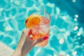 Tropical cocktail in female hand on background of swimming pool. Exotic summer Royalty Free Stock Photo