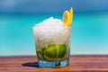 Tropical cocktail with fruits and ice on the wooden table at the beach with ocean