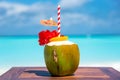 Tropical coconut cocktail with straw and umbrella on the wooden table at the beach with ocean Royalty Free Stock Photo