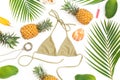 Tropical concept. Pineapple and mango fruits, palm leaves, cosmetics with bikini swimwear on white background. Flat lay, top view. Royalty Free Stock Photo