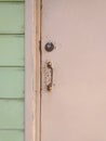 Close-up of pale pink rusty Caribbean house door, door handle, lock and light green wooden facade. Tropical Construction and Royalty Free Stock Photo