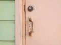 Close-up of pale pink rusty Caribbean house door, door handle, lock and light green wooden facade. Tropical Construction and Royalty Free Stock Photo