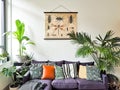 Tropical cozy living room with numerous houseplants and vintage insect poster on the wall Royalty Free Stock Photo