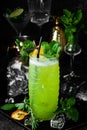 Tropical delicious green alcoholic cocktail - Jungle Juice. On a black stone background. Menu bar. Alcohol