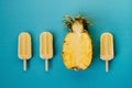 Tropical flat lay of three vegan popsicle and half of ripe pineapple