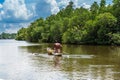 Tropical forest on the river bank .Fisherman floating in a boat.