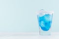 Tropical fresh alcohol cocktail with blue curacao liqueur, ice cube, salt rim in frozen shot glass on soft light white. Royalty Free Stock Photo