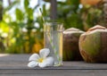 Tropical fresh coconut water in glass decorated plumeria on wooden background Royalty Free Stock Photo