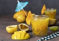 Tropical fresh juice mango, passionfruit and lime in two glasses on a dark background