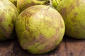 Tropical fruit on market - whole green coconut. Coconut peel texture. Coco palm fruit closeup photo.