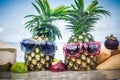 Tropical fruit mix on beach. Pineapple with sunglasses water reflection Royalty Free Stock Photo