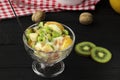 tropical fruit salad in glass bowl. Kiwi, banana and tangerine with yogurt