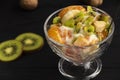 tropical fruit salad in glass bowl. Kiwi, banana and tangerine with yogurt