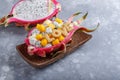 Tropical fruit salad served in half of dragon fruit on gray background. Word love made of cookie letters on top.  Healthy food Royalty Free Stock Photo