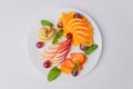 Tropical fruit salad on white plate on white background photographed from above. Royalty Free Stock Photo