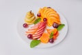 Tropical fruit salad on white plate on white background photographed from above. Royalty Free Stock Photo