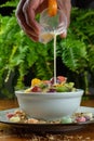 Hand pouring yogurt into fruit salad Royalty Free Stock Photo