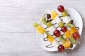 Tropical fruit on skewers with chocolate. horizontal top view