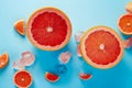 Tropical fruit summe red grapefruit berries and ice on blue background