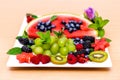 Tropical fruits assortment on a white plate , wooden background. Top view. Watermelon fresh fruit. Summer vegan food.