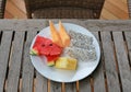 Tropical fruits assortment in white plate on wooden table Royalty Free Stock Photo