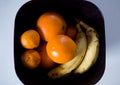 Tropical fruits in a black bowl on a white background Royalty Free Stock Photo