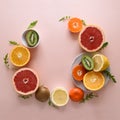 Tropical fruits frame from orange, lemon, tangerine and kiwi on pink paper background. Healthy food concept. flat lay. Top view Royalty Free Stock Photo