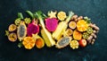 Tropical fruits - passion fruit, pineapple, dragon fruit, kiwi and cactus on a black background. Top view. Royalty Free Stock Photo