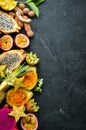 Tropical fruits - passion fruit, pineapple, dragon fruit, kiwi and cactus on a black background. Top view. Royalty Free Stock Photo