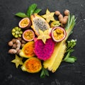 Tropical fruits - passion fruit, pineapple, dragon fruit, kiwi and cactus on a black background. Top view. Royalty Free Stock Photo