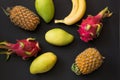 Tropical fruits pineapple, banana, dragon fruit and mango on black. Top view. Flat lay. Royalty Free Stock Photo