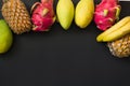 Tropical fruits pineapple, banana, dragon fruit and mango on black. Top view. Royalty Free Stock Photo