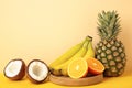 Tropical fruits. Pineapple, coconut, orange and banana on beige background Royalty Free Stock Photo