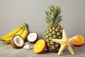 Tropical fruits. Pineapple, coconut, orange and banana on grey background Royalty Free Stock Photo