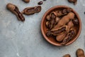 Tropical fruits, Tamarindo beans in shell on a brown butchers block on a dark background, healthy fruit. banner, menu, recipe Royalty Free Stock Photo