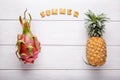 Tropical fruits on white. Dragon fruit and pineapple on white wooden background. Healthy food. Summer concept. Top view, copy