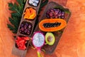 Healthy tropical fruits on wooden plate.